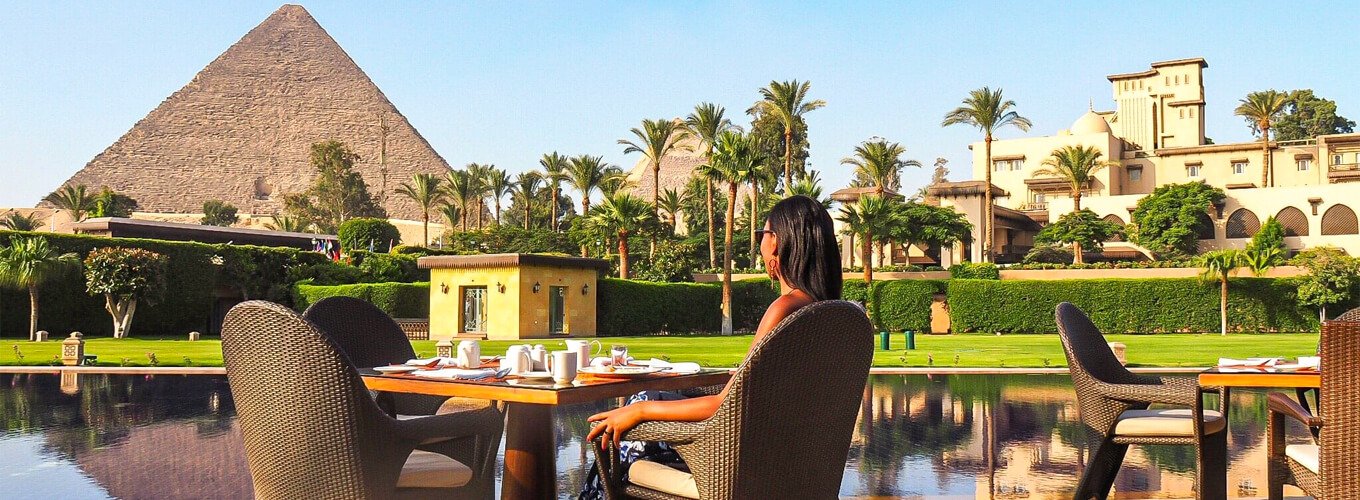 A-wonderful-photo-of-a-tourist-sitting-in-a-restaurant-in-front-of-the-pyramids